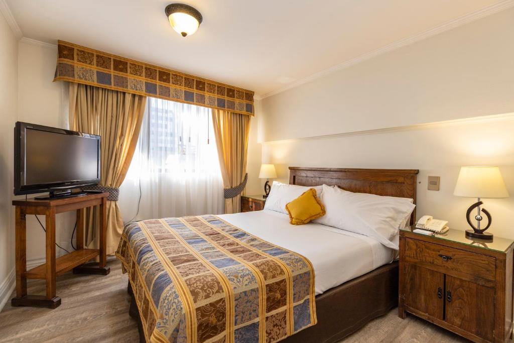 a hotel room with two beds and a television at Park Plaza Apartments in Santiago