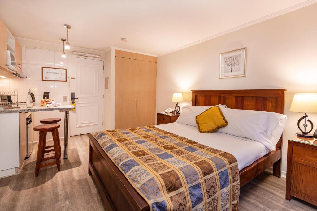 a hotel room with a bed and a kitchen at Park Plaza Apartments in Santiago