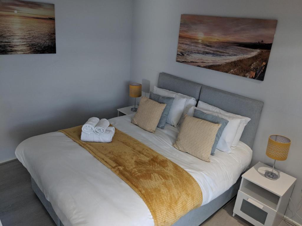 una camera da letto con un letto e due asciugamani di LT Grove Apartment - Stratford a Londra