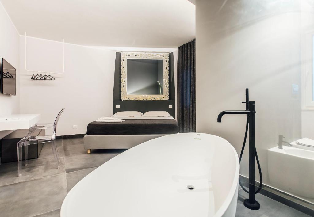 a bathroom with a bed and a sink and a mirror at Suite 106 in Vasto