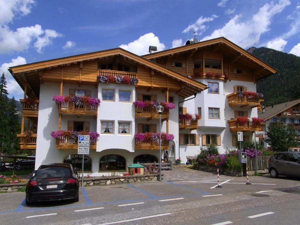 a large white building with flowers on the balconies at Casa Elisa in Pozza di Fassa