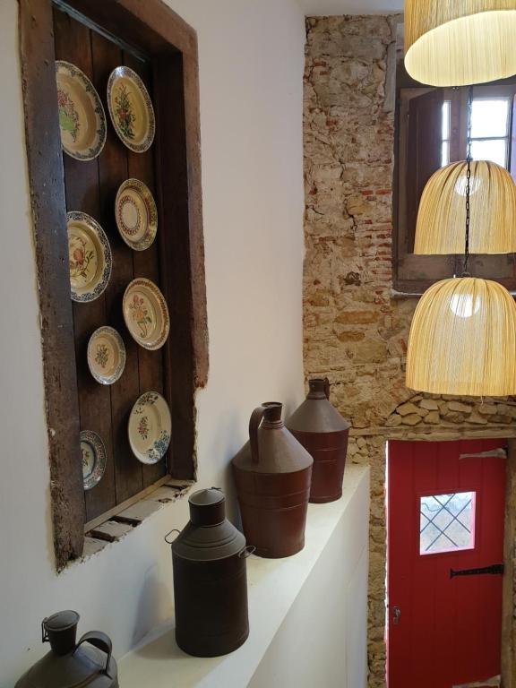 una pared con placas y jarrones en un estante en Casa da Sé Cathedral Suites, en Coímbra