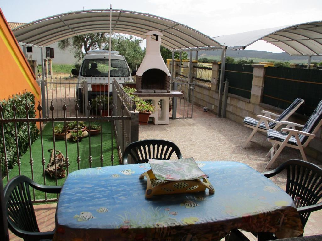un patio con tavolo, sedie e griglia di SoleMare sud sardegna a SantʼAnna Arresi