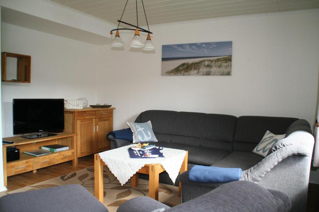 ein Wohnzimmer mit einem Sofa und einem Tisch in der Unterkunft Wohnung Schwalbennest in Süderende