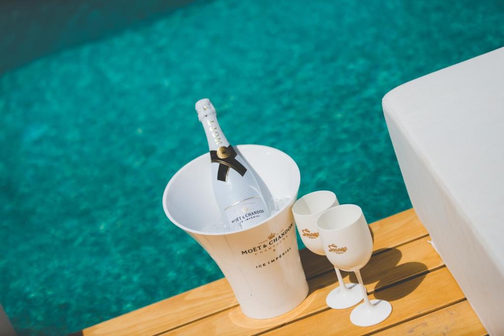 a wine glass with a bottle in it next to a pool at Super Paradise Hotel in Super Paradise Beach