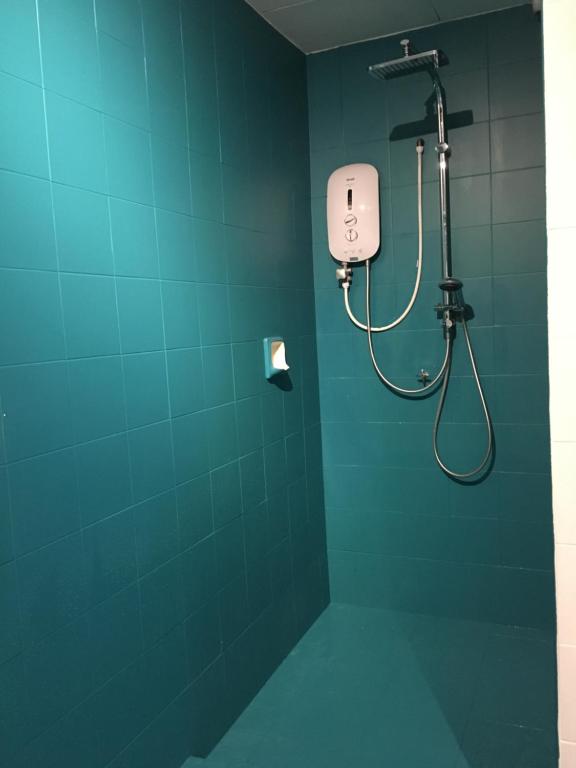 a bathroom with a shower in a blue wall at haus_22 in Bukit Mertajam