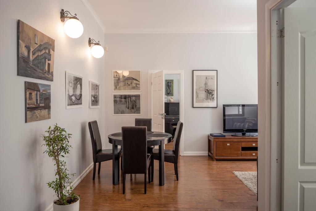 comedor con mesa, sillas y TV en Maironis Apartment, en Kaunas