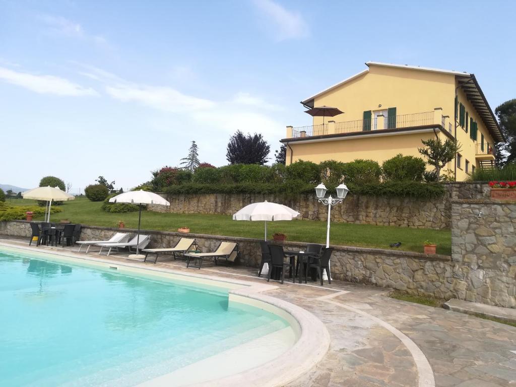 una villa con piscina y una casa en Casa dei Pini, en Cortona