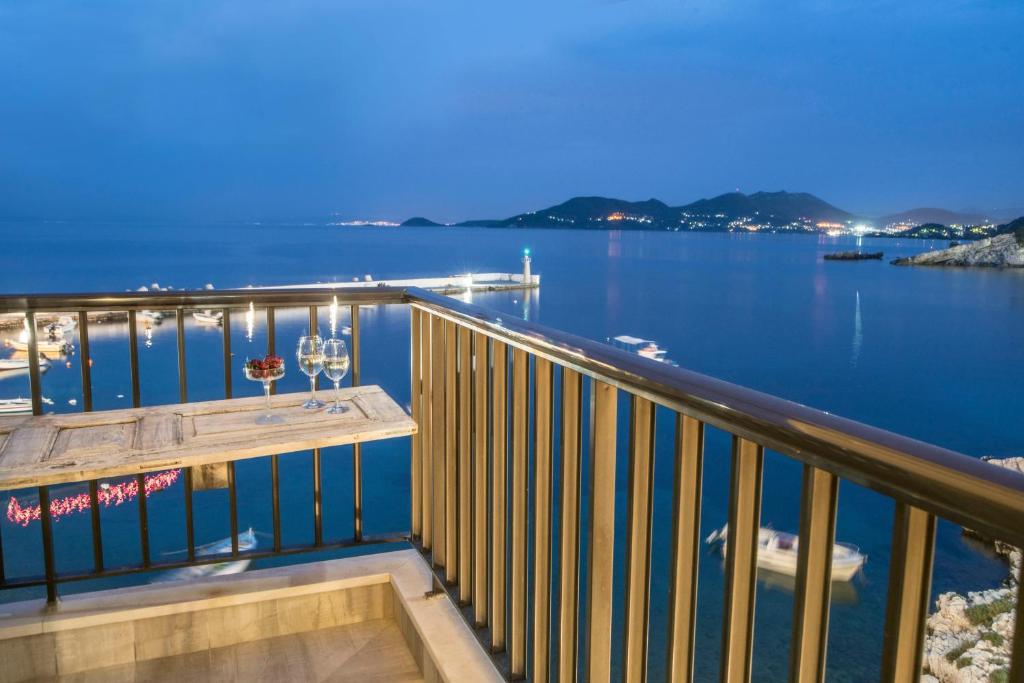 einen Balkon mit einem Tisch und Blick auf das Wasser in der Unterkunft Eftopia Beachfront 2-bedrooms apartment in Kokkari