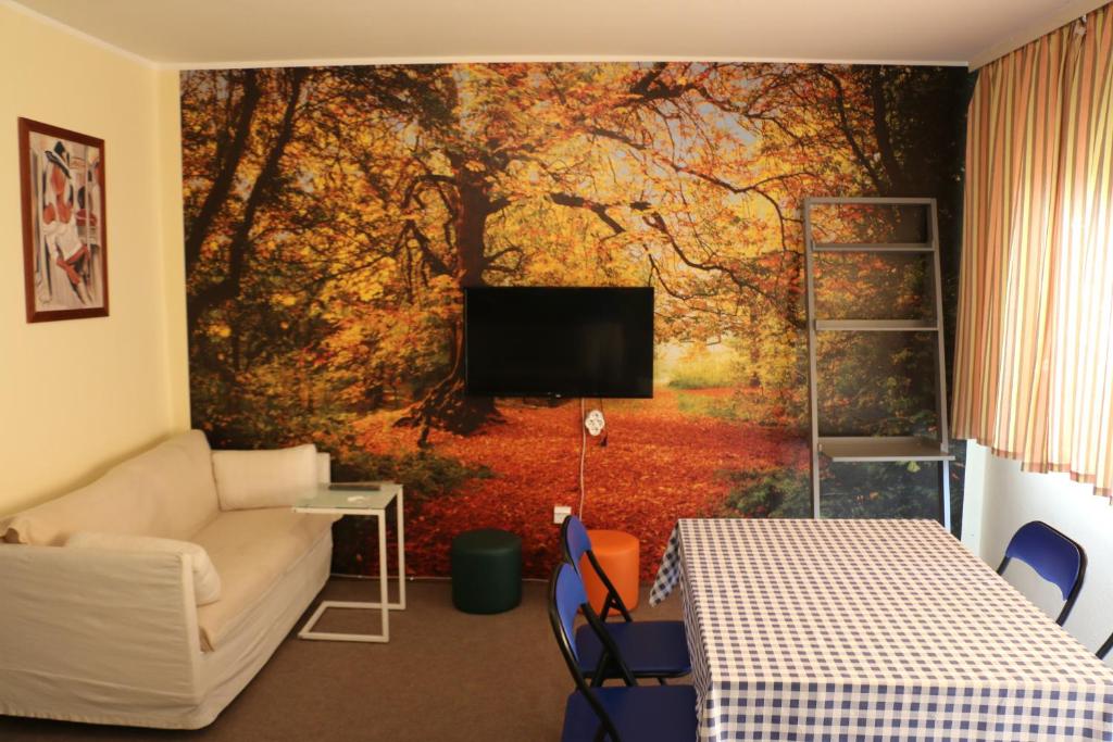 a living room with a wall mural of trees at Hostel Trajan in Donji Milanovac