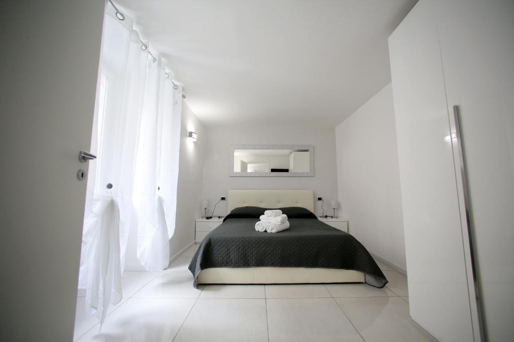 a white bedroom with a bed and a mirror at Live Naples in Naples