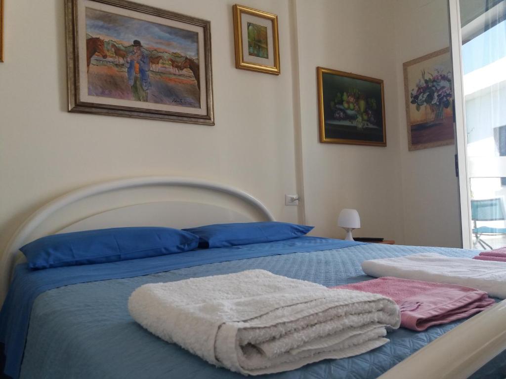 1 dormitorio con 2 camas y toallas. en B&B Villa Pegaso, en Fontane Bianche