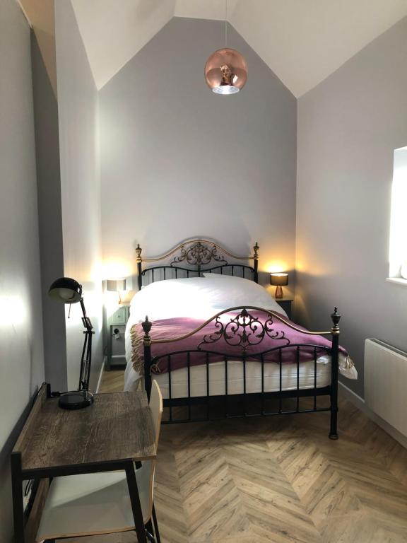 a bedroom with a bed and a table and a lamp at The Rhubarb Room in Barston