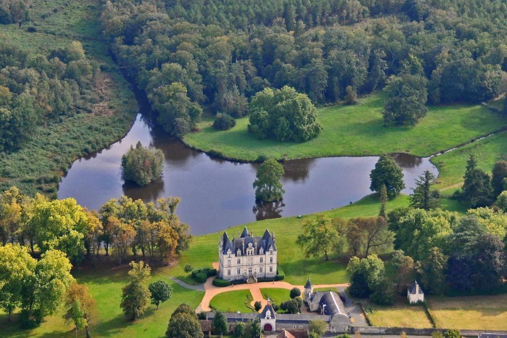 wyspa pośrodku jeziora z zamkiem w obiekcie Château du Maurier w mieście La Fontaine-Saint-Martin