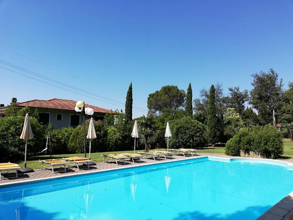 a large swimming pool with a blue sky at Hotel Monti in Lamporecchio