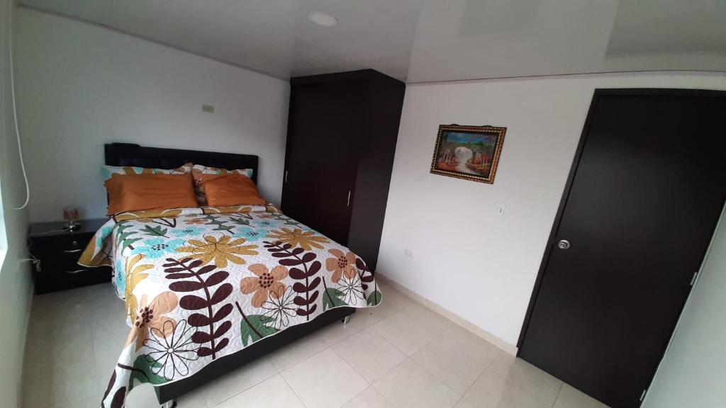 1 dormitorio con 1 cama con edredón de flores en Apartamentos YNJ, en Bogotá