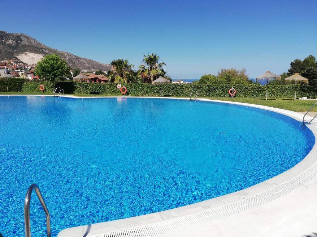 een groot zwembad met blauw water bij Benalmarina Sea View Apartments in Benalmádena