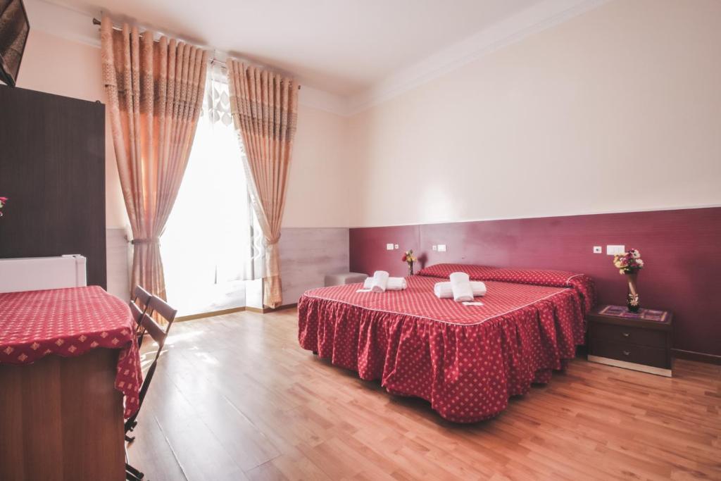 um quarto com 2 camas e uma grande janela em Vertex Guest House em Roma