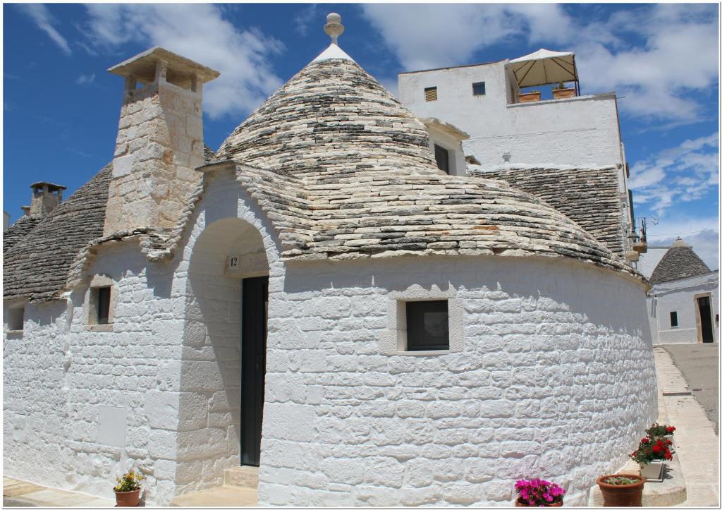 a white building with a roof with a tower at Il Trullo di Mari' - Locazione turistica in Alberobello