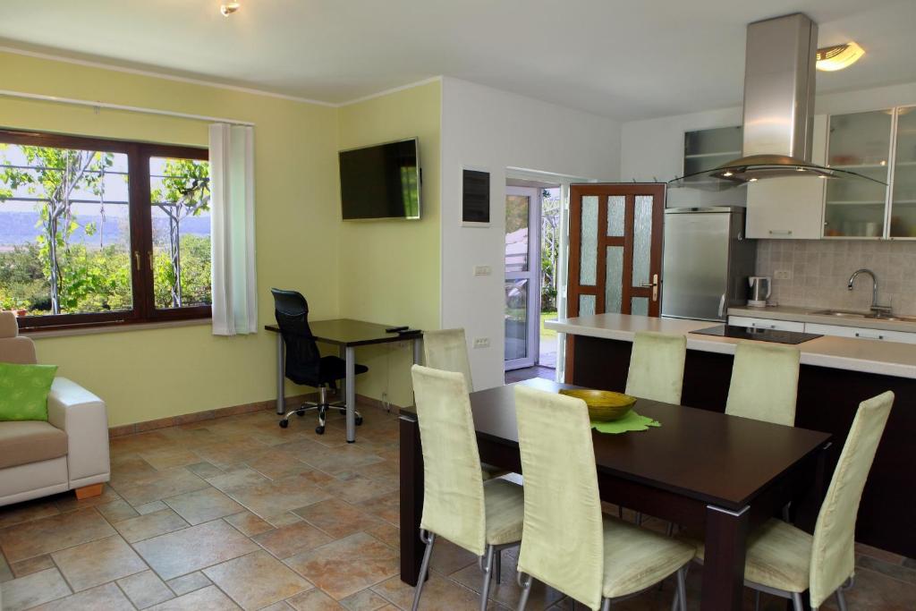 een keuken en eetkamer met een tafel en stoelen bij Salt Pans Apartment in Portorož