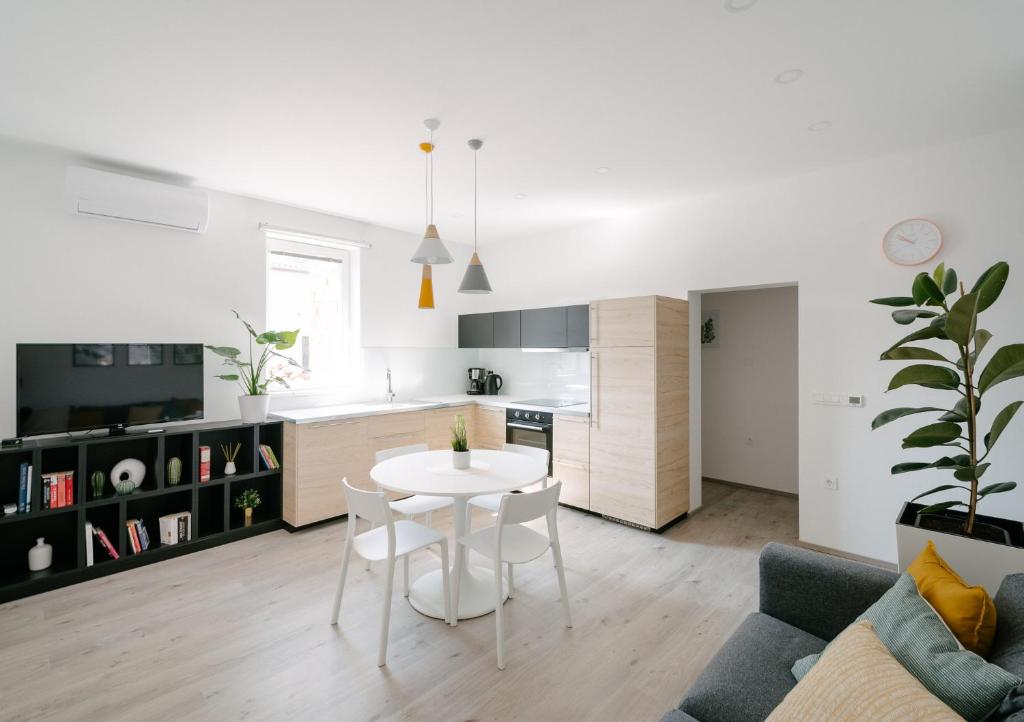 uma cozinha e sala de estar com uma mesa branca e cadeiras em Apartment Fresh - Parking included em Izola