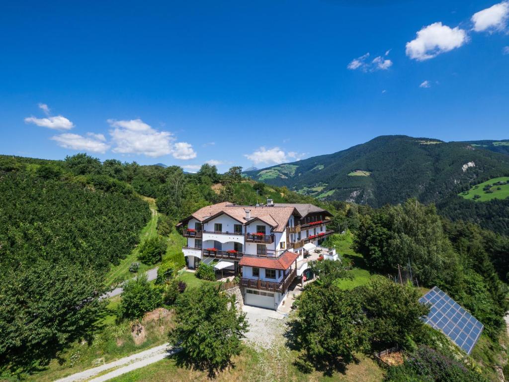 an aerial view of a house on a hill with mountains at Ferienpension Zummüllerhof in Natz-Schabs