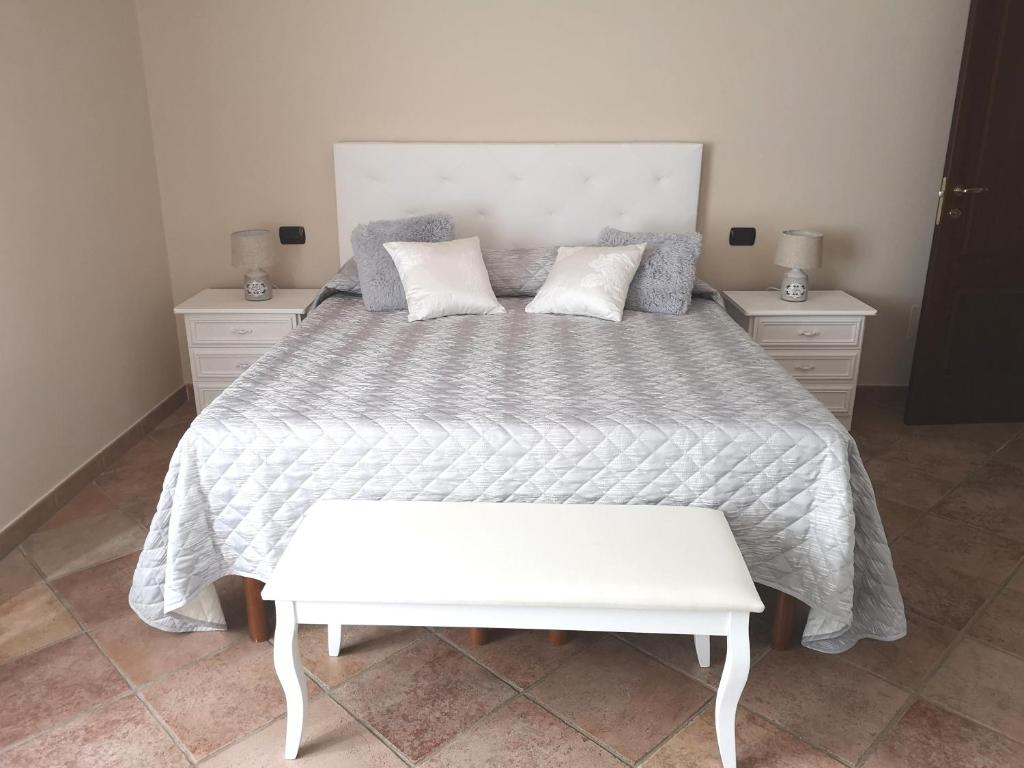 a bedroom with a large bed with a white comforter at Elisabeth's house in Iglesias