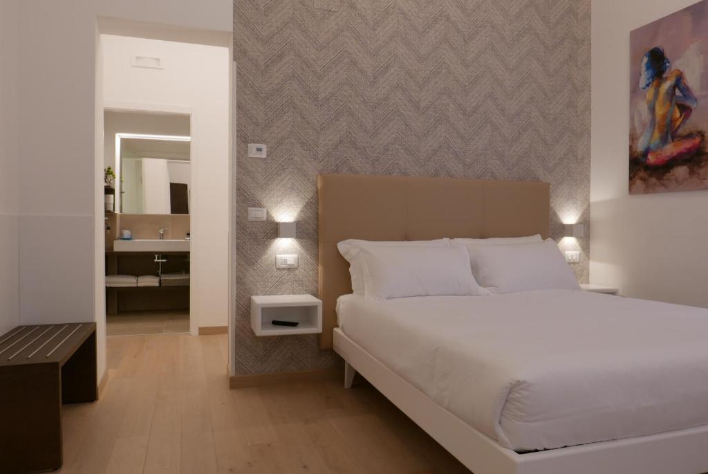 a bedroom with a white bed and a bathroom at S B&B (Pescara Centro) in Pescara
