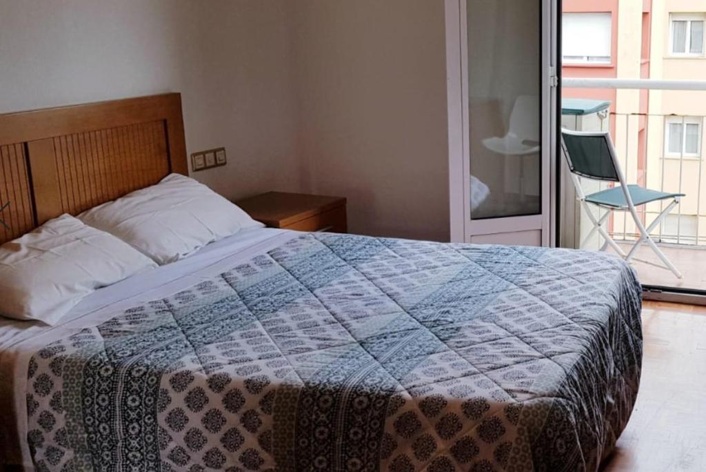 1 dormitorio con 1 cama con edredón azul y blanco en 3 Bedrooms SOHO Parking Included, en San Sebastián