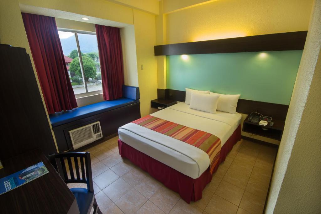 Postel nebo postele na pokoji v ubytování Microtel by Wyndham Batangas