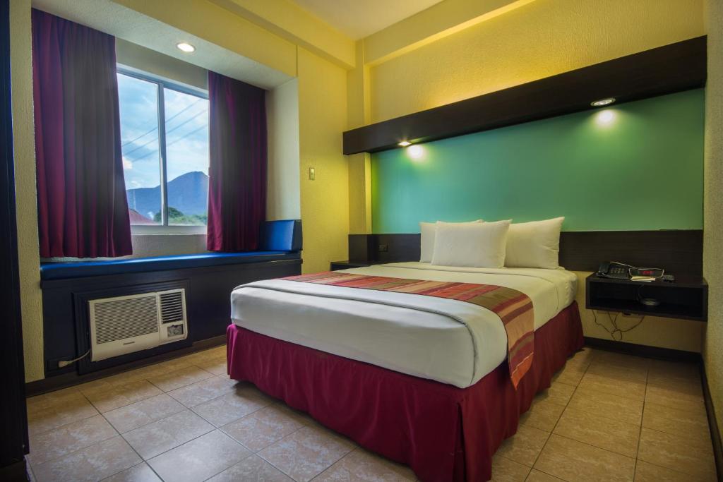 Postel nebo postele na pokoji v ubytování Microtel by Wyndham Batangas