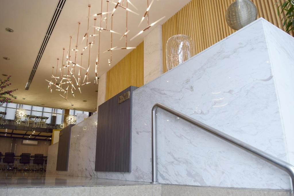 a lobby with a marble staircase and chandelier at Gran Mundo Hotel & Suites in Lima