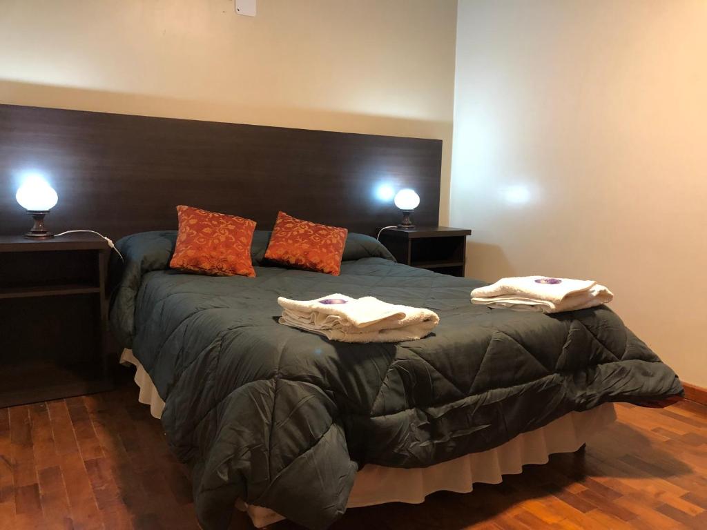 1 dormitorio con 1 cama grande y toallas. en Crystal Hotel en La Quiaca