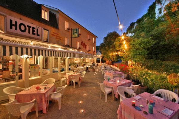 een restaurant met tafels en stoelen voor een gebouw bij Domaine de Lacave in Lacave