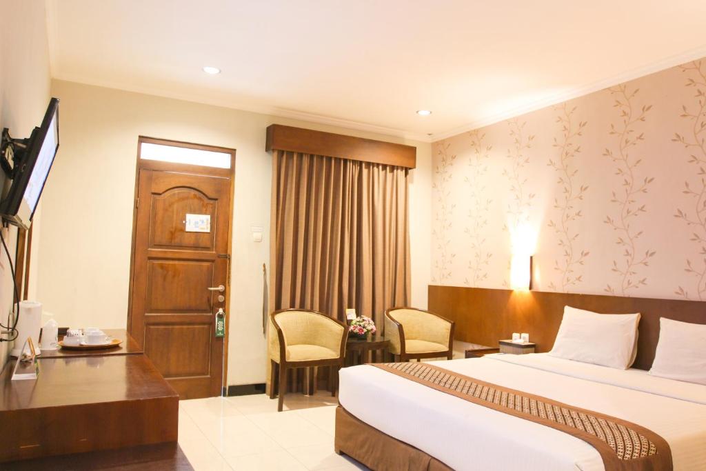 Postel nebo postele na pokoji v ubytování Cakra Kembang Hotel
