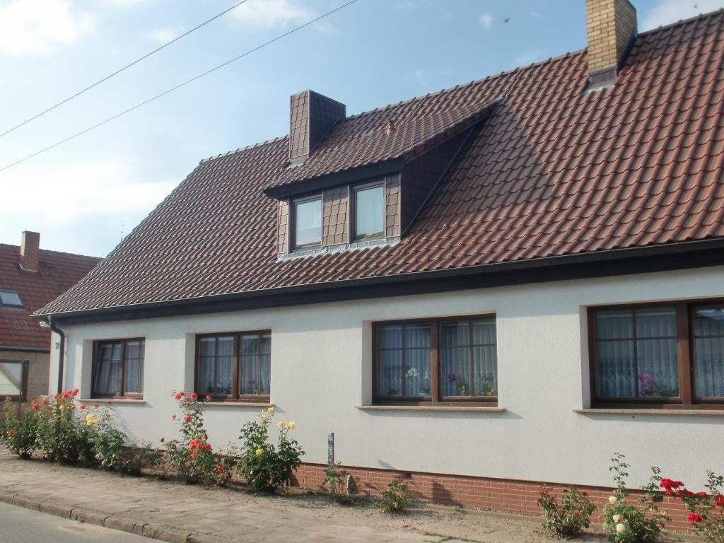 a white house with windows and a brown roof at Ferienwohnung Lisa in Gingst