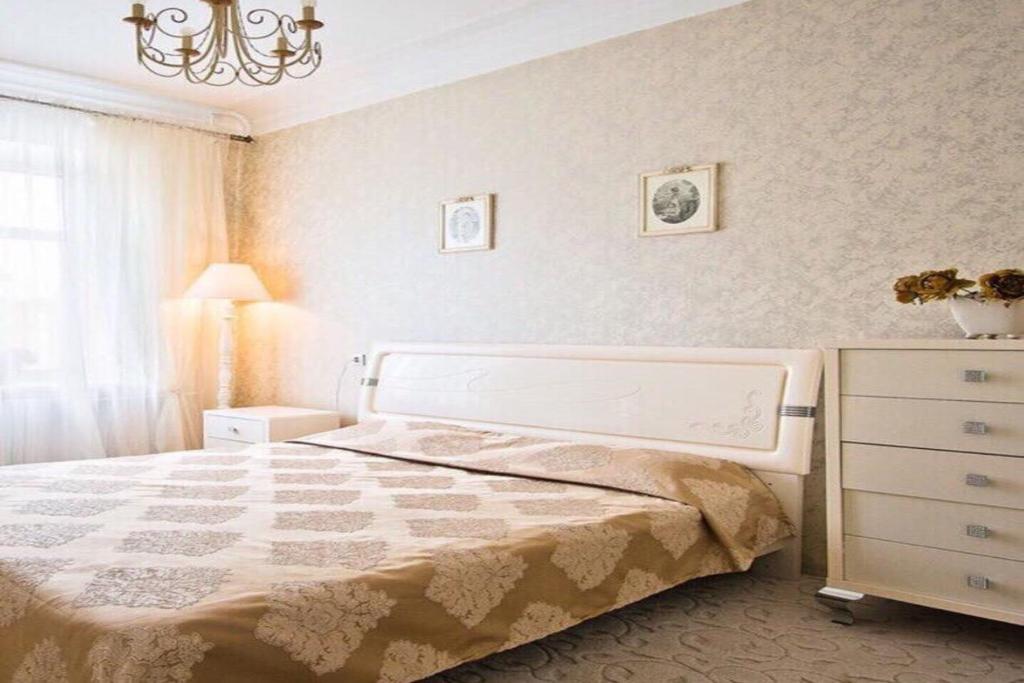 ein Schlafzimmer mit einem großen Bett und einer Kommode in der Unterkunft Apartment at the railway station in Minsk