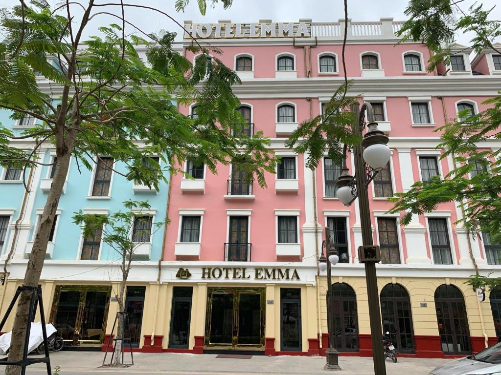 um edifício rosa e branco com um hotelarma em Emma Hotel em Ha Long