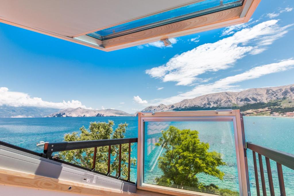 a balcony with a view of the water and mountains at Seaview Apartments Baska in Baška