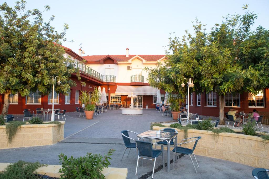 a courtyard with tables and chairs in front of a building at Hotel Mitra Crisálida in Cabra