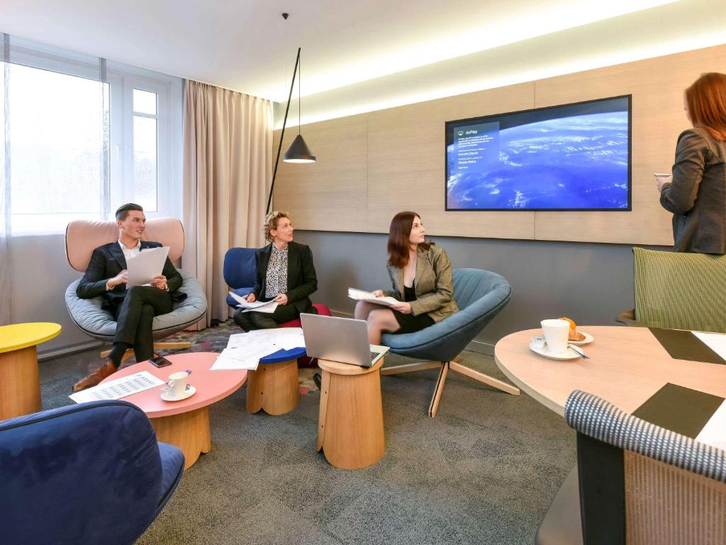 
people sitting around a living room at Novotel Wavre Brussels East in Wavre
