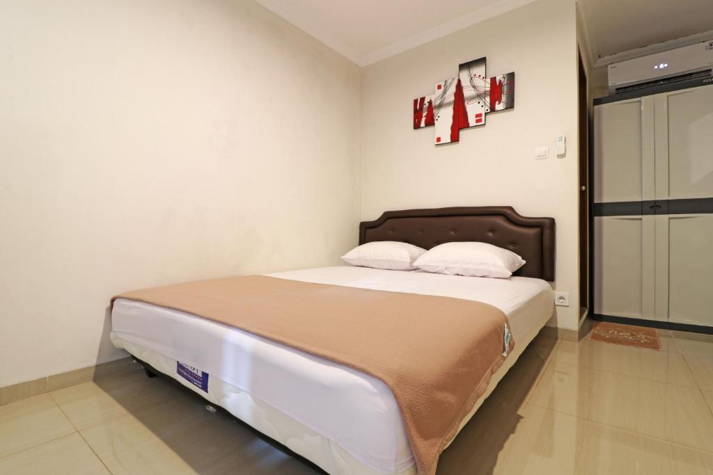 a bedroom with a large bed with two pillows at Wisma Surya in Pangkalanuringin