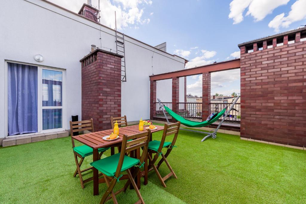 a patio with a table and chairs and a hammock at Sleepway Apartments- Green Dream in Poznań