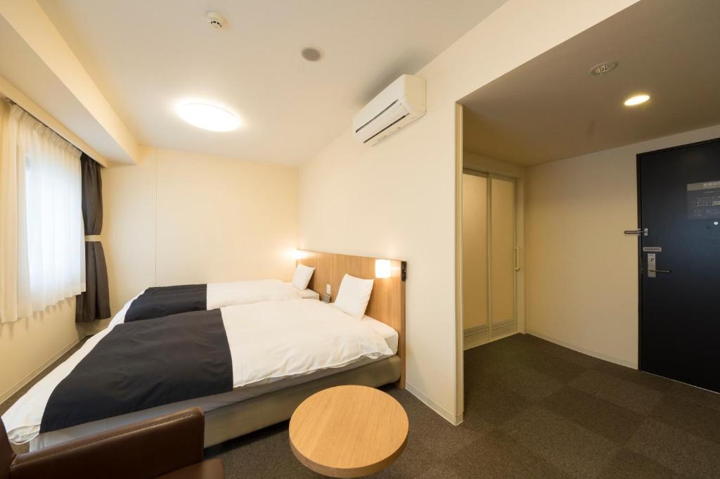 Postel nebo postele na pokoji v ubytování Dormy Inn Express Mikawaanjo