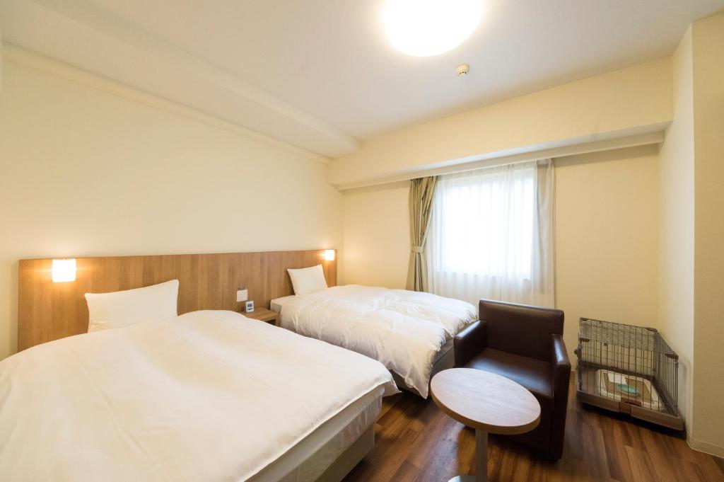 Postel nebo postele na pokoji v ubytování Dormy Inn Express Mikawaanjo