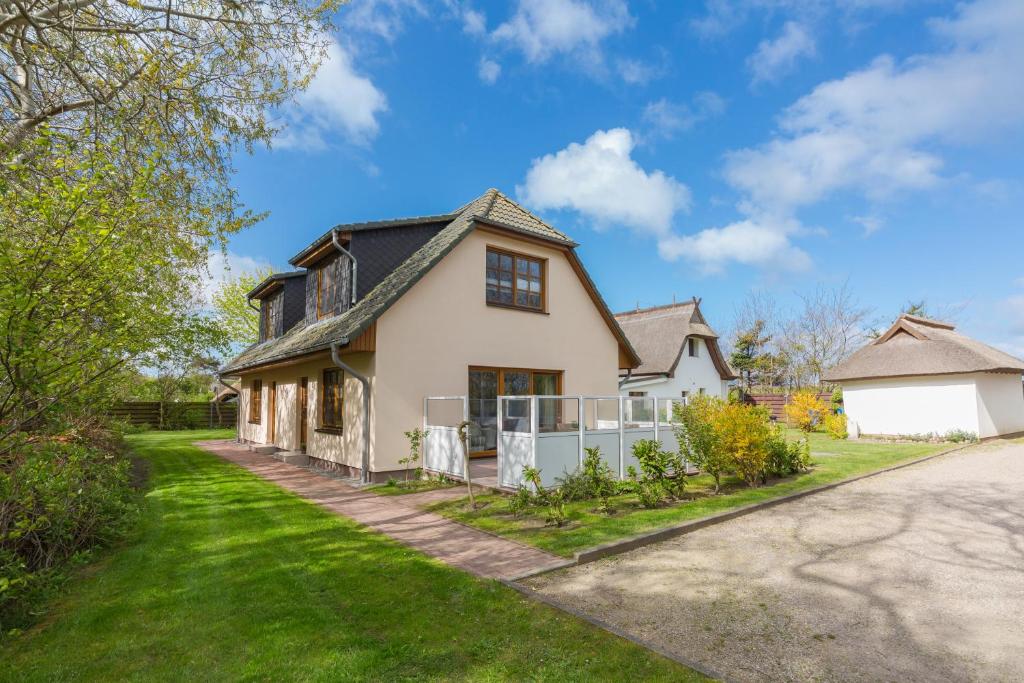 a white house with a black roof at Ferienhaus Dierhagen am Deich in Dierhagen