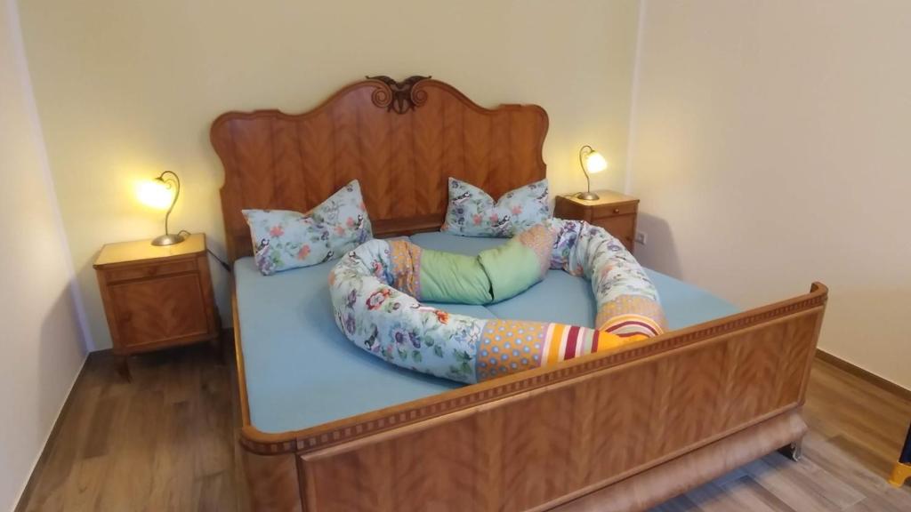 a bedroom with a bed with a headboard and two lamps at Mirabellenhof - Kleine Ferienwohnung mit Altstadtblick in Biesenthal