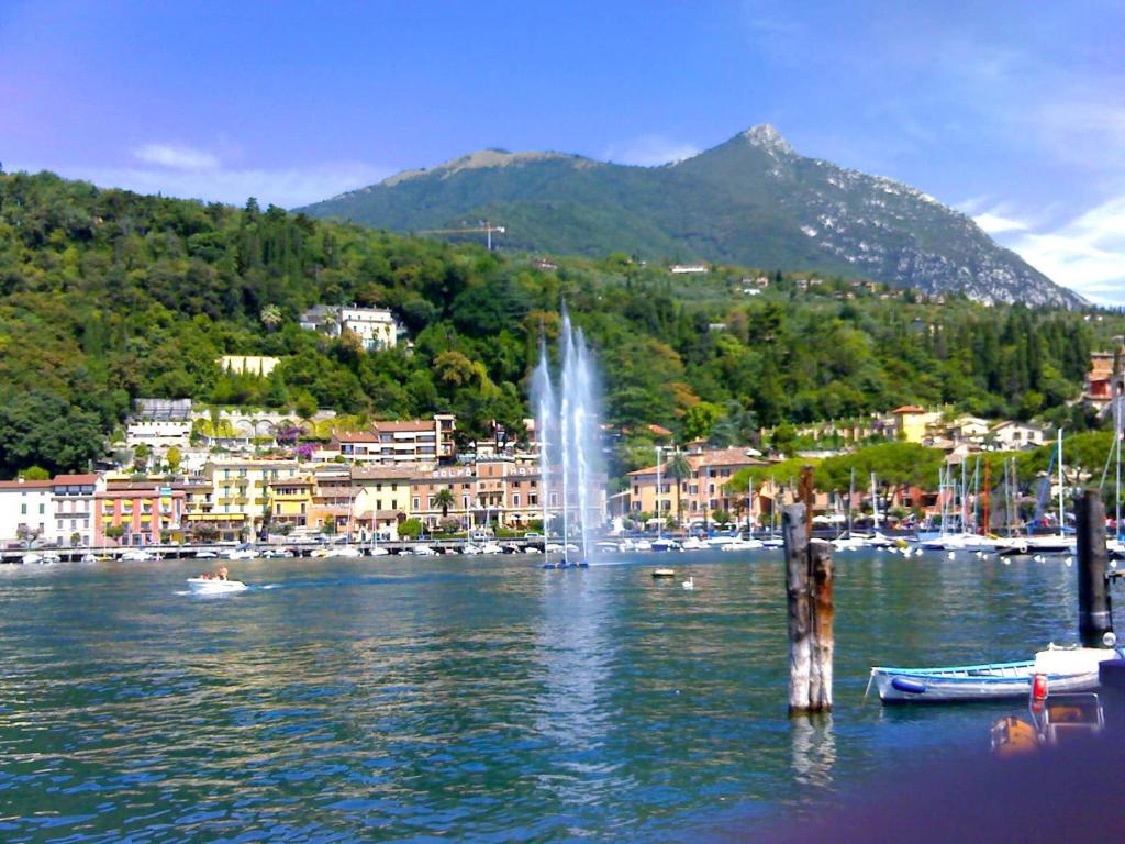a lake with a fountain in the middle of a city at HOTEL LORENA in Toscolano Maderno