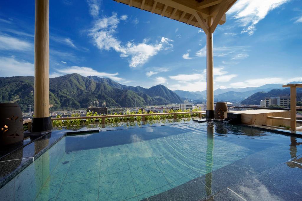 a pool at a resort with mountains in the background at Hotel Futaba in Yuzawa