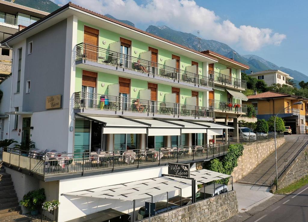 un hotel con mesas y sillas en un balcón en Albergo Villa Edera, en Malcesine